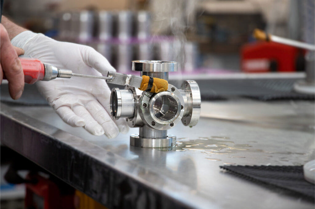 A photography of a persons hands doing a pickling process on a vakuum component