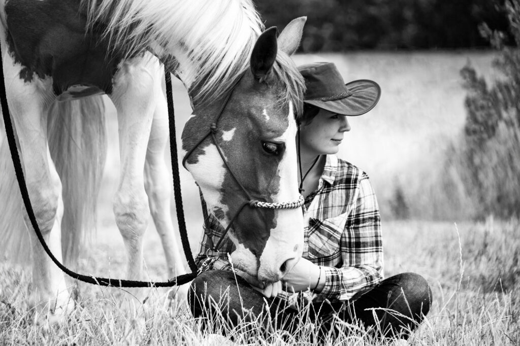 Black and white photography of a paint horse and her owner